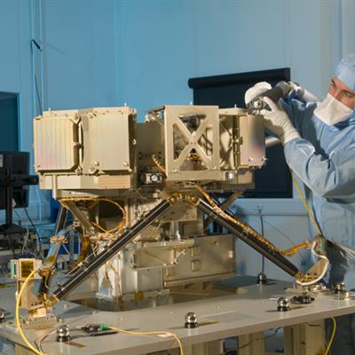 An engineer in a cleanroom suit performing alignment testing on MIRI.
