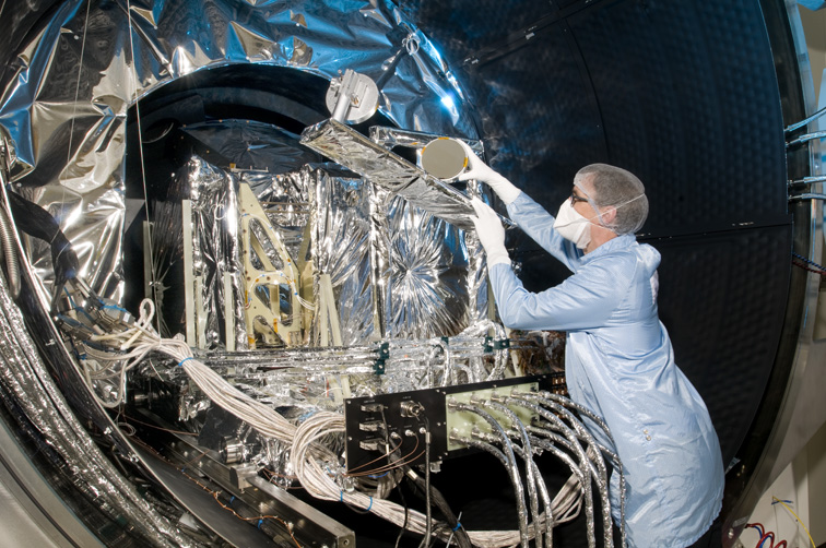 An engineer prepares SLSTR for testing in a vacuum chamber.