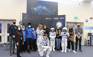 Students try on astronaut suits to celebrate completing their spacecraft challenge.