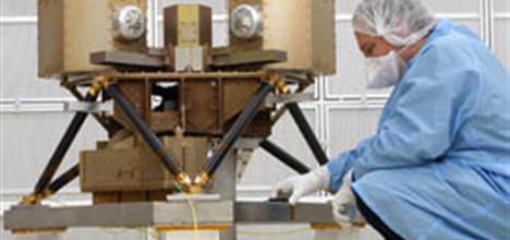 An engineer in a cleanroom suit working on the MIRI structural model.