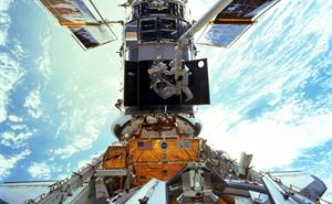 Astronauts Steven L. Smith, and John M. Grunsfeld repairing the Hubble Space Telescope.