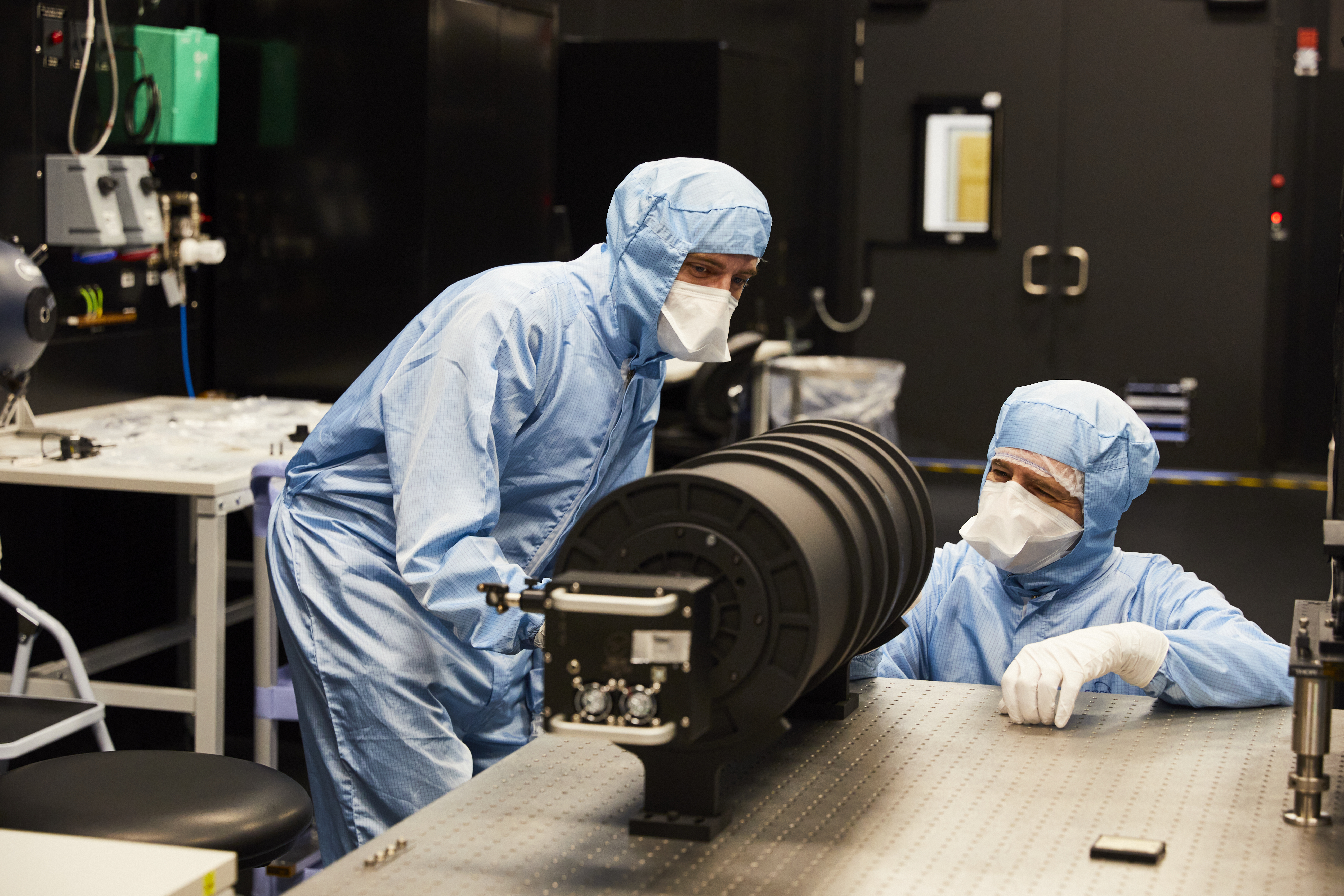 Two engineers working on an instrument in a dark room