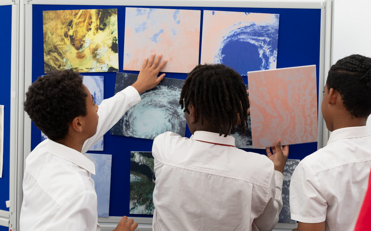 School children organising satellite images on a board.