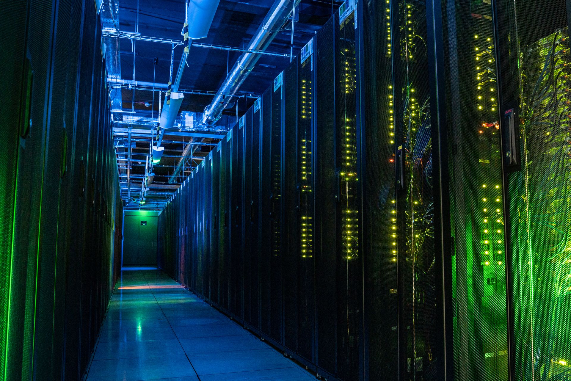 The JASMIN supercomputer, a long row of computer racks with blue and green lights.