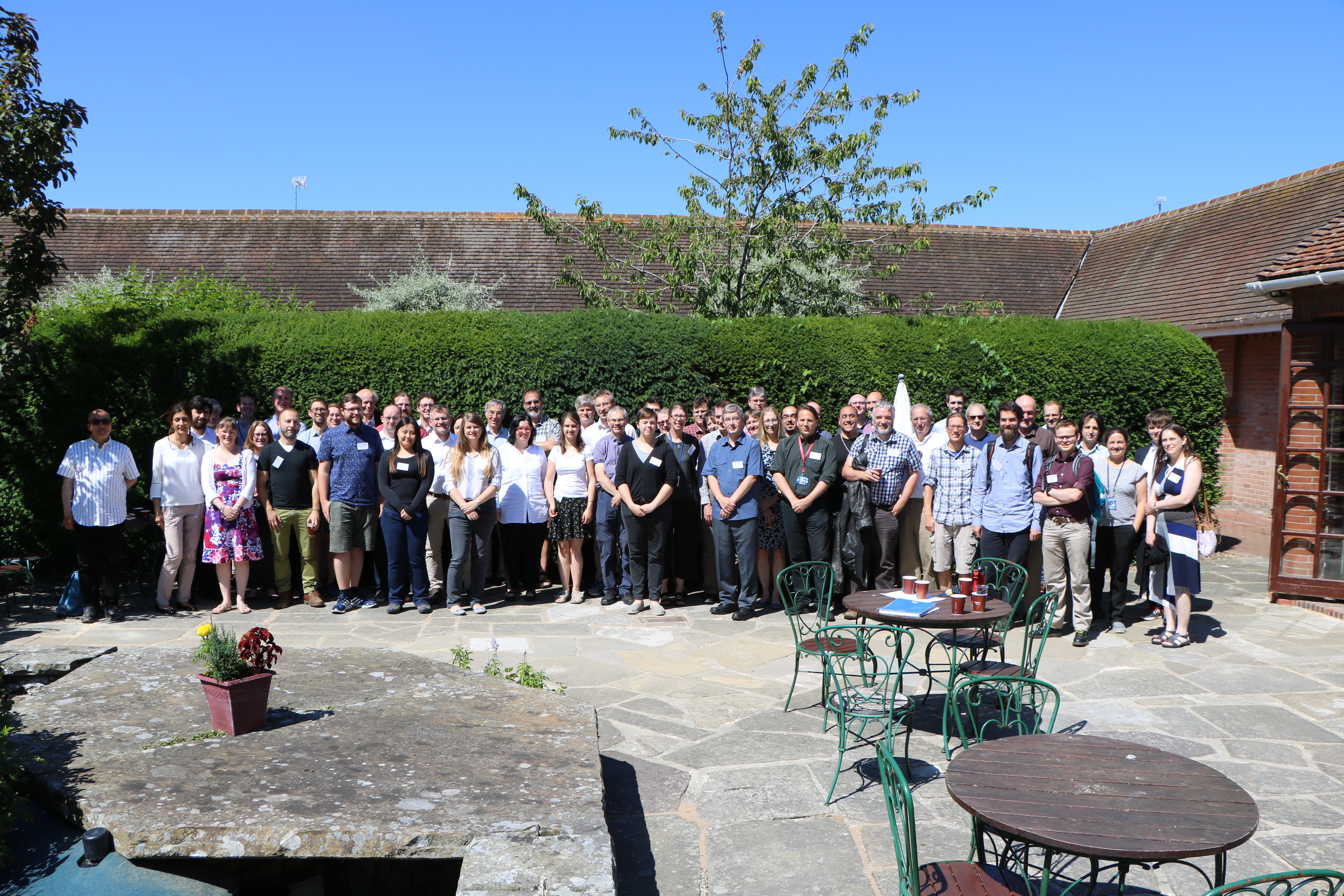 A large group of JASMIN users stand altogether in a courtyard.