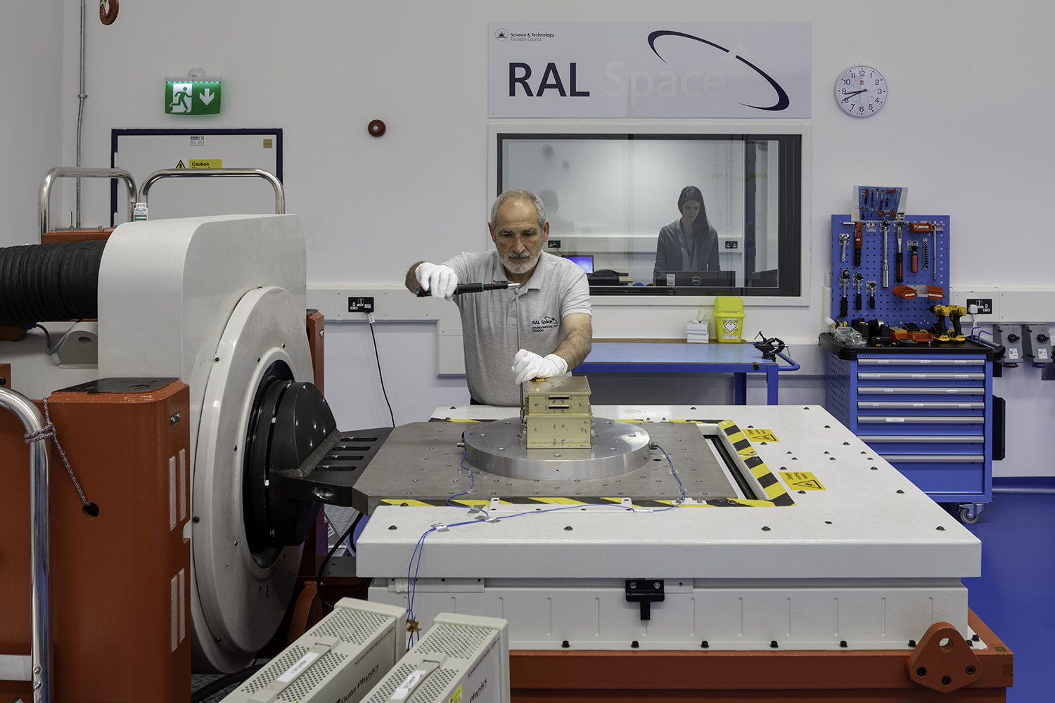 Technitian securing a payload to a vibration table 